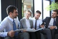 Group of four business people sitting on sofa. They couldn`t be happier about working together