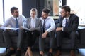 Group of four business people sitting on sofa. They couldn`t be happier about working together