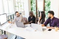 Group of four diverse business people working on laptop at meeting, business people working together in meeting room Royalty Free Stock Photo