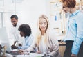 Group of four coworkers discussing business plans in modern office. Young people making great ideas. Horizontal, blurred Royalty Free Stock Photo