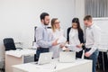 Group of four diverse men and women in casual clothing talking in office Royalty Free Stock Photo