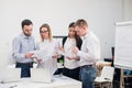 Group of four diverse men and women in casual clothing talking in office Royalty Free Stock Photo