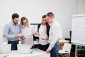 Group of four diverse men and women in casual clothing talking in office Royalty Free Stock Photo