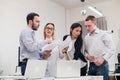 Group of four diverse men and women in casual clothing talking in office Royalty Free Stock Photo