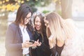 Group of four girl friends looking at phone on the selfie they w