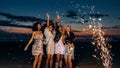 Group of four girlfriends dancing under confetti