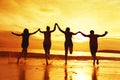 Group of four happy friends at sunset beach Royalty Free Stock Photo
