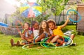 Four kids in a group sit with hula hoops on lawn Royalty Free Stock Photo