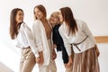 Group of four modern young women friends having fun at the cafe indoors.