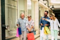 Group of four people going shopping together holding shopping bags with presents or gifts for christmas - buying clothes and more Royalty Free Stock Photo