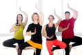 Group of four positive people doing Yoga practice in class