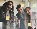 Group of four professional multiracial businessmen and businesswomen brainstorming and discussing by writing graph with a marker Royalty Free Stock Photo