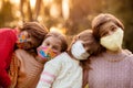 Group of four school-age girlfriends wearing protective masks await end of pandemic lockdown and back to normality