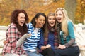 Group Of Four Teenage Girls Sitting On Bench Royalty Free Stock Photo