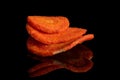 Dried vegetable chips isolated on black glass