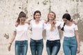 Group of diverse girls in tshirts and jeans over street wall Royalty Free Stock Photo