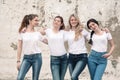 Group of diverse girls in tshirts and jeans over street wall Royalty Free Stock Photo