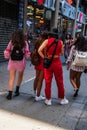 Group of four young girls seen from the back wearing backpacks walking on a Manhattan, New York city sidewalk