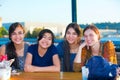 Group of four young women smiling together by lake Royalty Free Stock Photo