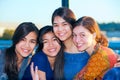 Group of four young women smiling together by lake Royalty Free Stock Photo