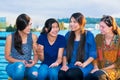 Group of four young women talking together by lake Royalty Free Stock Photo