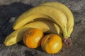 The group of fresh banan and mandarins on a wooden cutting board