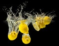 Group of fresh fruits falling in water with splash on black background Royalty Free Stock Photo