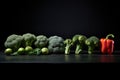 Group of fresh green broccoli and red bell pepper on black background Royalty Free Stock Photo
