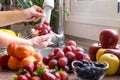 Group of fresh red fruit and woman`s hands washing grape under the jet of water Royalty Free Stock Photo