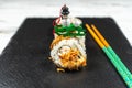 Group of fresh sushi with wooden chopsticks on a black stone plate board and on a white rusty background.Soft focus shot Royalty Free Stock Photo