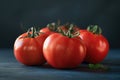 A group of fresh tomatoes sit on top of a wooden table, ready for use or display Royalty Free Stock Photo