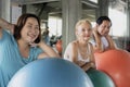 Group friend of senior at yoga gym posing leaning on her ball smiling and happy. elderly healthy lifestyle