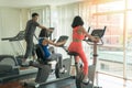 Friends athletes doing exercises together on gym machines in fitness center. Workout, sport, lifestyle concept