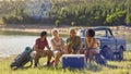 Group Of Friends With Backpacks By Pick Up Truck On Road Trip Drinking Beer From Cooler By Lake Royalty Free Stock Photo