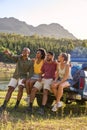 Group Of Friends With Backpacks In Pick Up Truck On Road Trip By Lake And Mountains Royalty Free Stock Photo