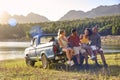 Group Of Friends With Backpacks In Pick Up Truck On Road Trip By Lake And Mountains Royalty Free Stock Photo