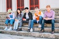 group of friends browsing with their mobile phones sitting outdoors. Royalty Free Stock Photo