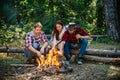 Group of friends camping with marshmallows over a camp fire. Spring or autumn camping. Picnic time. Young people eating Royalty Free Stock Photo