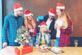 Group of friends celebrating Christmas at home with champagne while sharing presents Royalty Free Stock Photo