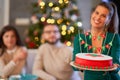 Group of friends celebrating Christmas at home with fancy cake Royalty Free Stock Photo