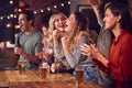 Group Of Friends Celebrating Watching Sports Game Or Match Drinking In Bar Together Royalty Free Stock Photo