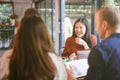 Group of friends chatting and using laptop in cafe at the coffee shop cafe in university talking and laughing together. Royalty Free Stock Photo