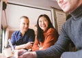 Group of friends chatting and using laptop in cafe at the coffee shop cafe in university talking and laughing together. Royalty Free Stock Photo