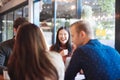 Group of friends chatting and using laptop in cafe at the coffee shop cafe in university talking and laughing together, Royalty Free Stock Photo