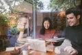 Group of friends chatting and using laptop in cafe at the coffee shop cafe in university talking and laughing together, view throu Royalty Free Stock Photo