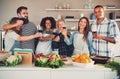 Group of friends cheering at kitchen.