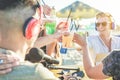 Group of friends cheering with tropical cocktails at video feed from beach kiosk party - Young people having fun toasting drinks Royalty Free Stock Photo