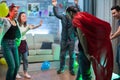 Group of friends cheering up for men with superhero cape