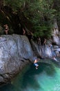 Group of friends climbing a diving cliff of a beautiful lagoon