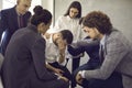 Group of friends or colleagues comforting sad young man who's hiding his face and crying Royalty Free Stock Photo